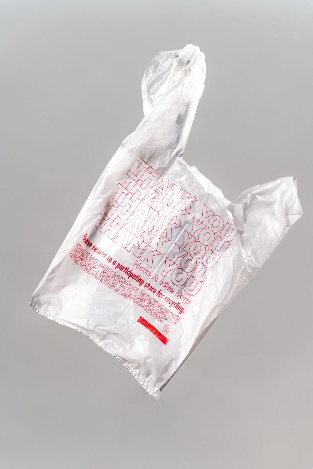 A white plastic bag with a message that says it can be returned to a participating store for recycling